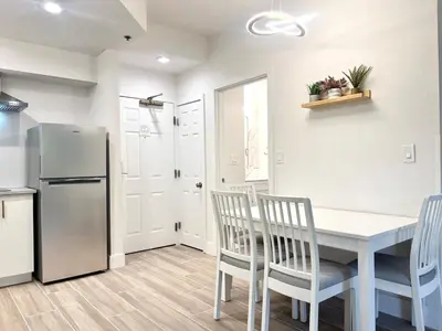 a kitchen with a table and chairs and a refrigerator at Condo close to Epic Universe - free parking in Orlando