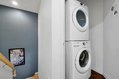 a washer and dryer in a white laundry room at Charming Oasis with King Bed Close to Disney 4BR in Kissimmee