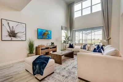 a living room with white furniture and a large window at Casa Luxuosa 5Q c/ Piscina Perto da Disney! in Kissimmee