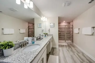 a bathroom with two sinks and two mirrors at Casa Luxuosa 5Q c/ Piscina Perto da Disney! in Kissimmee