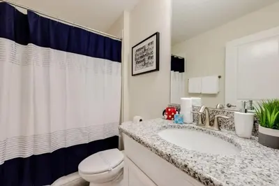 a white bathroom with a sink and a toilet at Casa Luxuosa 5Q c/ Piscina Perto da Disney! in Kissimmee