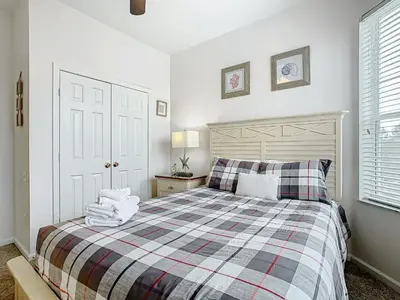 a bedroom with a bed with a checkered blanket at Windsor Hills Amazing 3BR Condo,Pool,Slides,Disney in Orlando