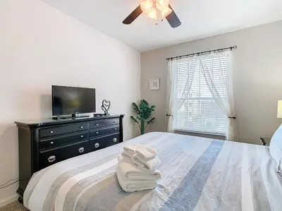 a bedroom with a bed with a television and a dresser at Windsor Hills Amazing 3BR Condo,Pool,Slides,Disney in Orlando