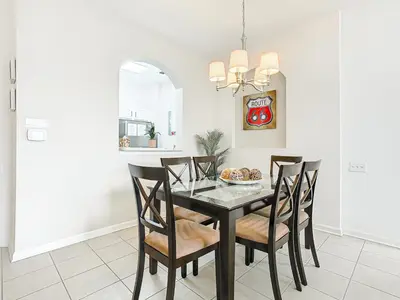 a dining room with a black table and chairs at Windsor Hills Amazing 3BR Condo,Pool,Slides,Disney in Orlando
