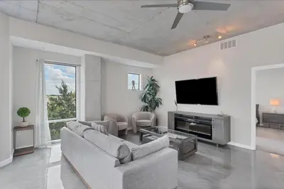 a living room with a couch and a flat screen tv at Modern 3 bedroom condo in downtown w free parking in Orlando