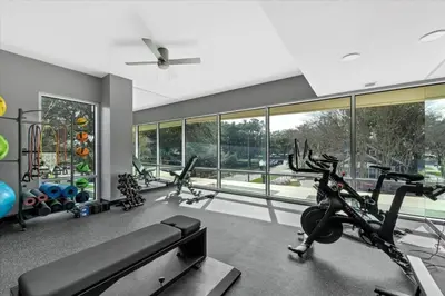 a gym with treadmills and ellipticals in a room with windows at Modern 3 bedroom condo in downtown w free parking in Orlando