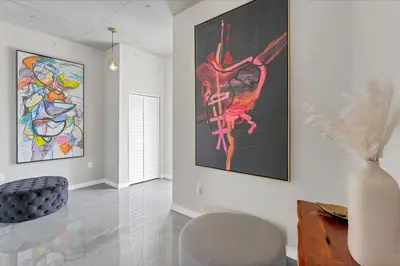 a living room with paintings on the wall and a vase at Modern 3 bedroom condo in downtown w free parking in Orlando