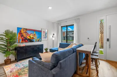a living room with two blue couches and a tv at Colorful vibrant Oasis Sleeps 10, 10min to Disney in Kissimmee