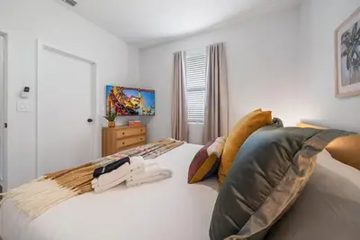 a bedroom with a white bed with two pillows at Colorful vibrant Oasis Sleeps 10, 10min to Disney in Kissimmee