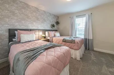 two beds in a room with a brick wall at Casa 4Q com Piscina Privativa Próxima à Disney in Kissimmee