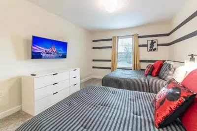 a bedroom with two beds and a tv on the wall at Casa 4Q com Piscina Privativa Próxima à Disney in Kissimmee