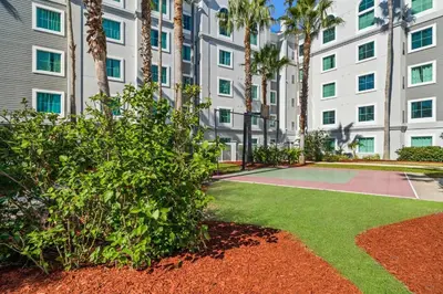 a garden with a basketball court in front of a building at Disney Potter Condo FREE Shuttle & Parking in Orlando
