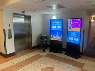a hallway with an elevator and a sign on the wall at Disney Potter Condo FREE Shuttle & Parking in Orlando