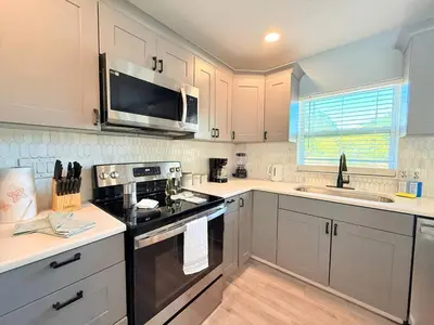 a kitchen with stainless steel appliances and white cabinets at Spacious Orlando Stay Free Wifi Game Room in Orlando