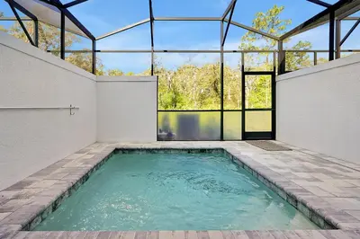an indoor swimming pool in a building with glass windows at Relaxing Nature Escapade with Game Room in Orlando