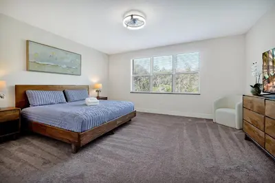 a bedroom with a bed and a dresser and a window at Relaxing Nature Escapade with Game Room in Orlando
