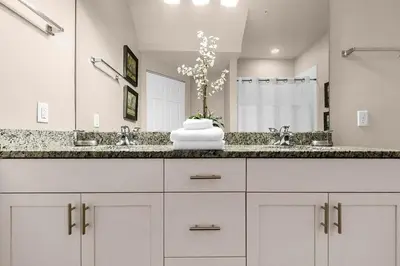 a white bathroom with a sink and a mirror at Casa 3Q Lucaya – 10 Min da Disney c/ Clubhouse in Kissimmee