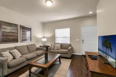 a living room with a couch and a table at Casa 3Q Lucaya – 10 Min da Disney c/ Clubhouse in Kissimmee