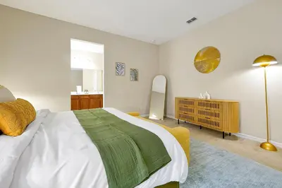 a bedroom with a large bed with a green blanket on it at 5BR Disney Villa with Private Pool & Spa in Kissimmee