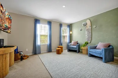 a living room with two chairs and a tv at 5BR Disney Villa with Private Pool & Spa in Kissimmee