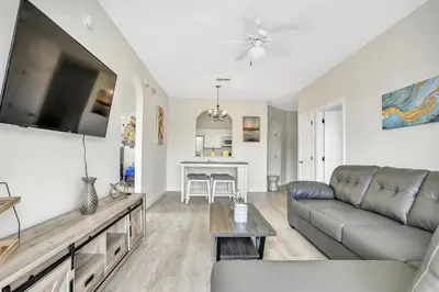 a living room with a couch and a flat screen tv at 8102-3-PP-Vacation getaway condo at Windsor in Kissimmee