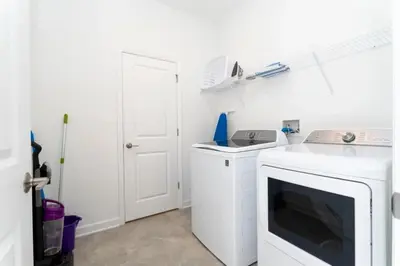 a white laundry room with a washer and dryer at Casa 5Q Storey Lake – Resort & Piscina in Kissimmee