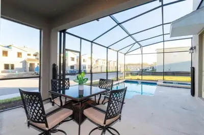 a patio with a table and chairs and a pool at Casa 5Q Storey Lake – Resort & Piscina in Kissimmee