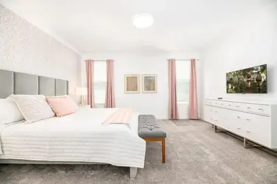 a white bedroom with a large bed and a dresser at Casa de 6 Quartos no Storey Lake perto da Disney in Kissimmee