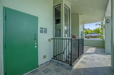 a hallway with a green door in a house at Sunny Sales - Renovated TownHome by Disney! in Orlando