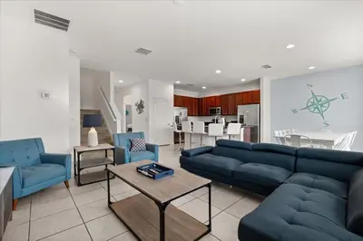 a living room with a blue couch and blue chairs at Summer Deal - Amazing 8BR Home with Private Pool! in Kissimmee