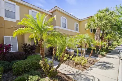 a row of palm trees in front of a building at Cozy 3bd Townhouse Near Disney Encantada Resort in Kissimmee