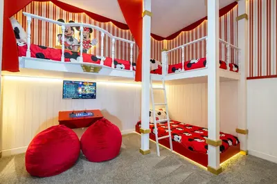 a childs bedroom with a bunk bed with red sheets at Vibrant 5Bd w Private Pool & Waterpark at Storey Lake 4811M in Kissimmee