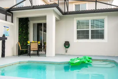 a toy frog laying in the water in front of a house at Vibrant 5Bd w Private Pool & Waterpark at Storey Lake 4811M in Kissimmee