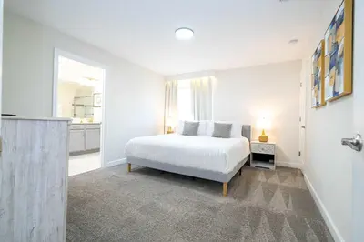 a white bedroom with a bed and a window at Vibrant 5Bd w Private Pool & Waterpark at Storey Lake 4811M in Kissimmee