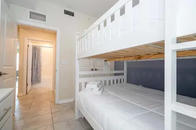 a bedroom with a white bunk bed and a staircase at Gorgeous 2Bd Close to Disney at Storey Lake Resort in Kissimmee