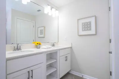 a white bathroom with a sink and a mirror at Family Condo 2Bd Close to Disney at Storey Lake Resort in Kissimmee