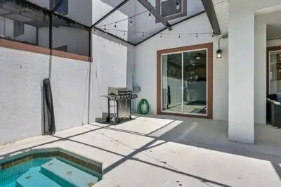a backyard with a swimming pool and a grill at Casa com Piscina Privativa a 10 Min da Disney in Kissimmee