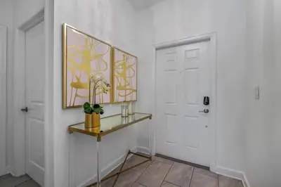 a hallway with a door and a shelf with a plant at Casa com Piscina Privativa a 10 Min da Disney in Kissimmee