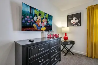 a bedroom with a dresser and a painting on the wall at Casa com Piscina Privativa a 10 Min da Disney in Kissimmee