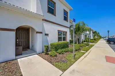 a building with a sidewalk next to a street at Casa com Piscina Privativa a 10 Min da Disney in Kissimmee
