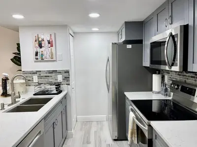 a kitchen with a sink and a refrigerator at Grand Superior 3BR Condo Apartment Near Disney Parks in Kissimmee
