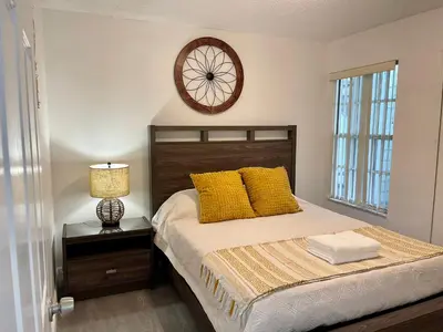 a bedroom with a bed with a clock on the wall at Grand Superior 3BR Condo Apartment Near Disney Parks in Kissimmee