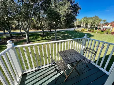 a wooden bench sitting on a white railing on a porch at Grand Emerald 3BR Townhouse Near Disney Parks in Kissimmee