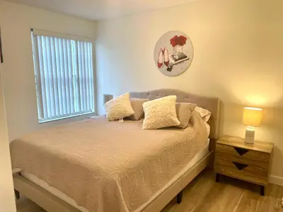 a bedroom with a bed and a window and a clock at Dream Superior 3BR Condo Near Disney Parks in Kissimmee