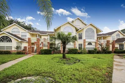 a large house with a palm tree in the yard at Dream Superior 3BR Condo Near Disney Parks in Kissimmee