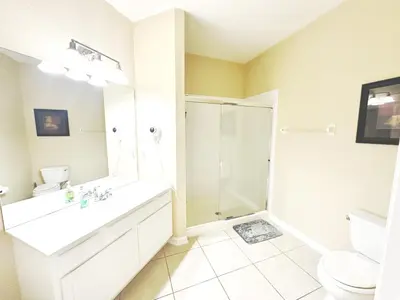 a white bathroom with a shower and a sink at King Room with Bathroom near Convention Center & Epic Universe in Orlando