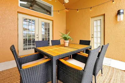 a dining room table with chairs and a wooden table at 5BR Cottage w Pool & Hot Tub Near Disney in Kissimmee