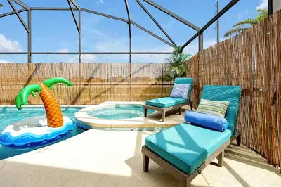 a swimming pool with two chairs at 5BR Cottage w Pool & Hot Tub Near Disney in Kissimmee