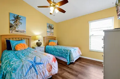 a bedroom with two beds and a ceiling fan at 5BR Cottage w Pool & Hot Tub Near Disney in Kissimmee