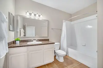 a bathroom with a sink and a toilet and a mirror at Modern Pet-Friendly - 2BR Condo - 6 mins from Disney in Orlando
